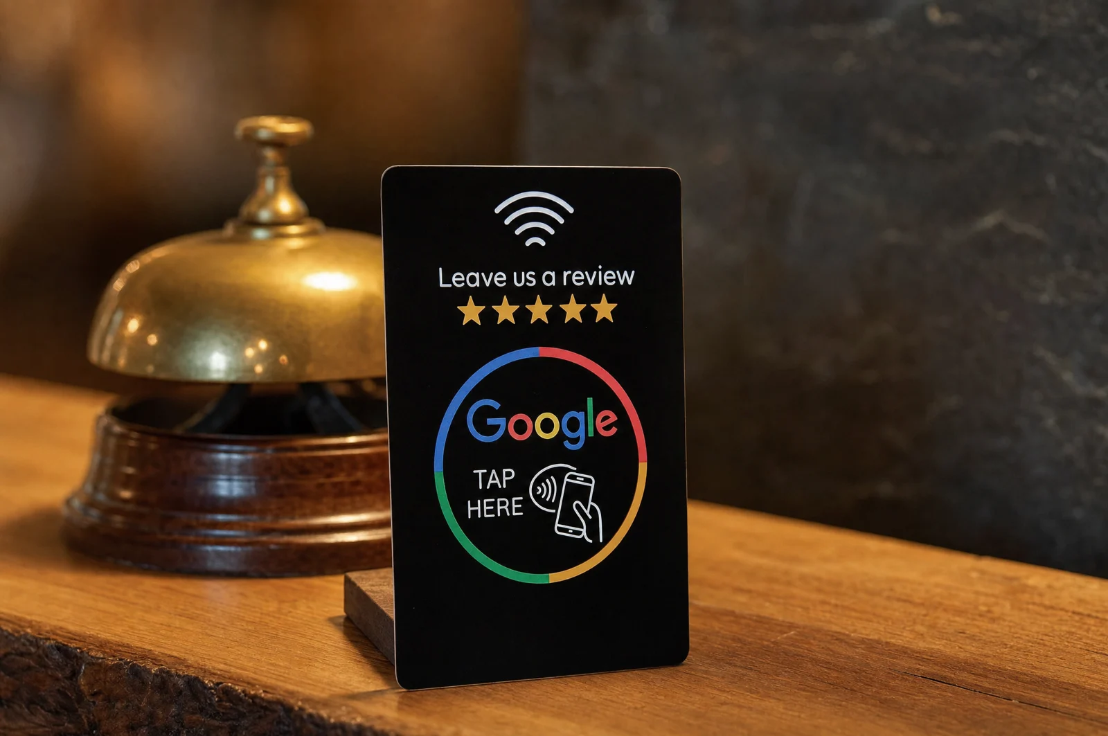 Card recensioni NFC accanto al campanello d’ottone della reception di un hotel